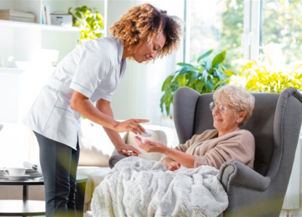 A carer helping a resident with her medication